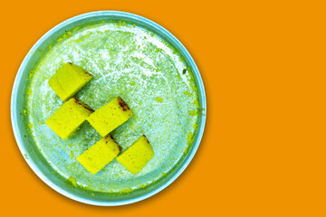 Gujarati famous dhokla in white plate Isolated with Orange Color Background