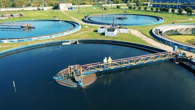 Top view of male workers standing at the wastewater plant