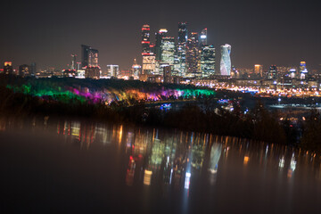 Die moderne Skyline Moskaus bei Nacht, in bunten Farben strahlend und reflektierend