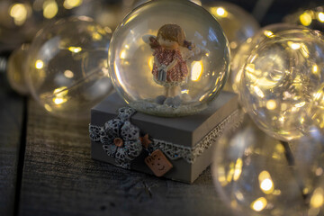 decorative snow globe with a girl angel on a dark wooden background