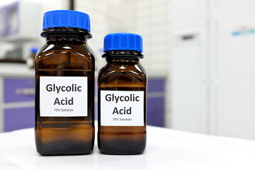 Selective focus of glycolic acid liquid solution in dark brown glass bottle in a white chemistry...
