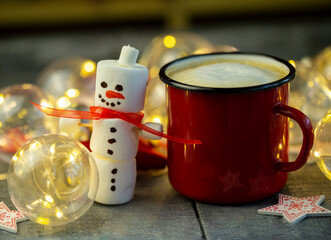a marshmallow snowman with a red coffee Cup in a close-up Christmas decoration