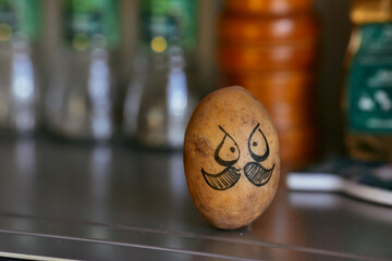 Potatoes on a blurred background. Potatoes with a painted face. Political concept with potatoes....