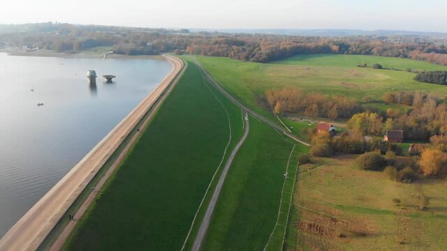 Aerial drone 4k forward movement over dam and reservoir with walkway and walkers