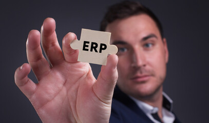 Business, Technology, Internet and network concept. Young businessman shows the word: ERP