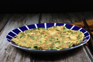 Deep fried mixed egg with cutting spring onion on the plate. Famous traditional comfort menu in the morning. 