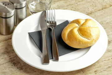 assiette, couverts et pain sur une table
