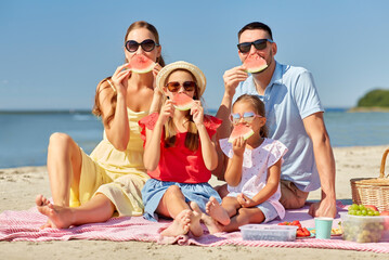 family, leisure and people concept - happy mother, father and two daughters having picnic on summer...