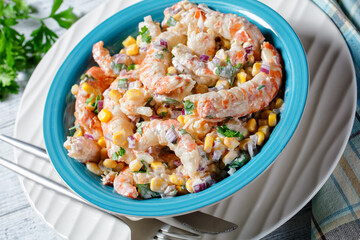 Shrimp salad with corn on a blue plate, close-up
