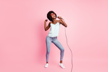 Full body photo of carefree person dancing singing light blue singlet isolated on pink color background