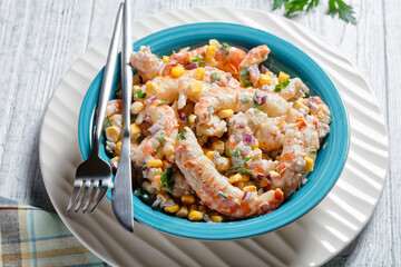 Shrimp salad with corn on a blue plate, close-up