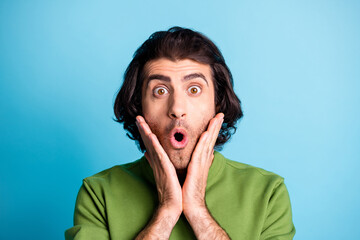 Close up portrait of impressed person staring open mouth hands on cheeks wear sweater isolated on blue color background