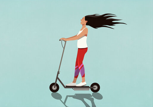 Carefree young woman riding electric scooter
