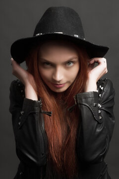 young ginger rock style woman in black hat and leather jacket