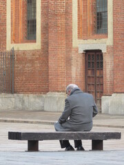 Fototapeta na wymiar anziano seduto sulla panchina della piazza - Depressione e solitudine