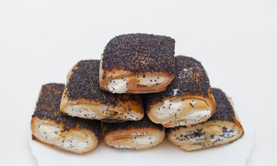 butter cookies with filling and poppy seeds on a white plate on a white background