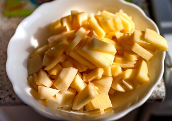 Sliced potatoes on a white plate closeup
