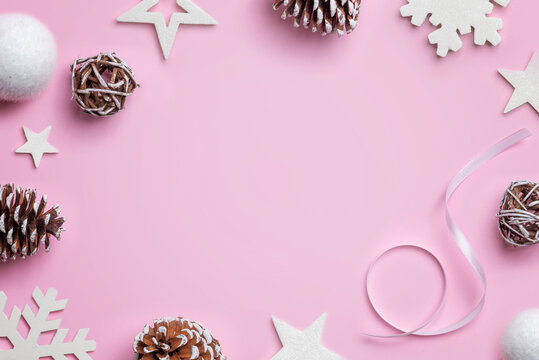 Christmas composition on pink desk. White stars, balls, snowflakes and cones. Christmas background. Top view, flat lay