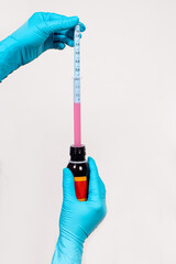 The doctor picks up from the bottle a sprinkle of cough and temperature for children in a measuring...