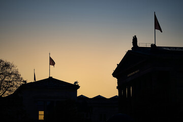 Blick auf die Silhouette der Alten Nationalgalerie und des Neues Museums auf der Berliner Museumsinsel im Gegenlicht der untergehenden Abendsonne - Inschrift: "Der Deutschen Kunst MDCCCLXXI"