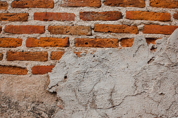 Cracked concrete vintage brick wall background. Red brick walls have old concrete walls framed around. Place for text. Banner concept.