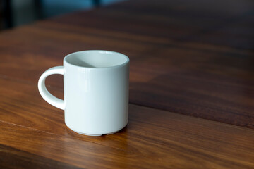 White coffee mug on the wood in the morning time