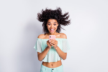 Photo portrait of girl with hair blowing away holding phone in two hands isolated on white colored...