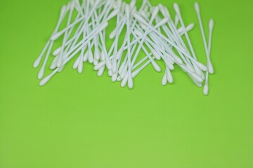 White cotton buds isolated on lime green background