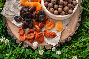 Different chicken and macadamia nut on a wooden background on the grass. Photo for the catalog. Assortment of dried fruits