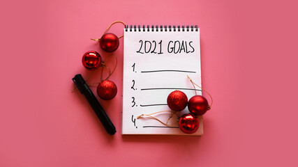 Naklejka na ściany i meble Goal list for 2021 concept. Top view, flat lay, copy space - pink background with Christmas balls and black marker