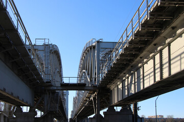 Fototapeta premium Silhouettes of arched spans of the rilway double-track bridge. The view from under the bridge