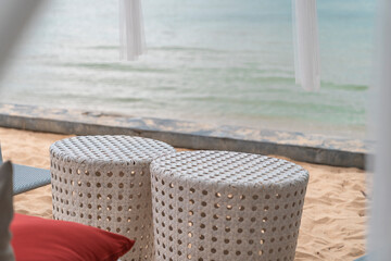 Fototapeta na wymiar close-up couple white weave chair on sand beach near sea, place for relax with ocean view