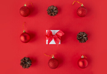 New Year or Christmas composition. Cones, shiny and matte balls, gift with bow. Geometric holiday card. Flat lay