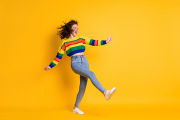 Full length profile photo of lady dance wear striped cropped sweater denim jeans footwear isolated yellow color background