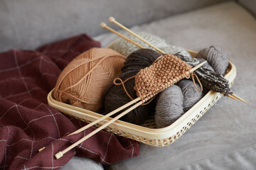 Close-up of wool and needles for knitting on the sofa