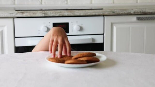 child stealing a cookie while is mother is not watching.