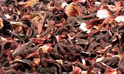 Full frame of dried Sudanese rose or hibiscus petals isolated on white background. Red tea, karkade. Food background concept.