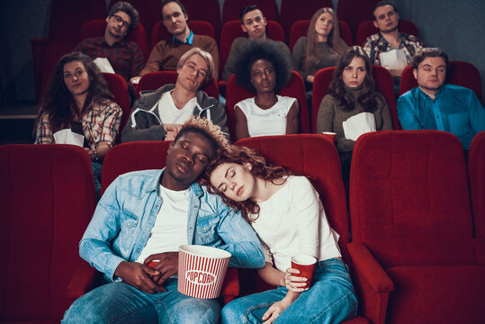 Multiethnic couple in love is sleeping in cinema.