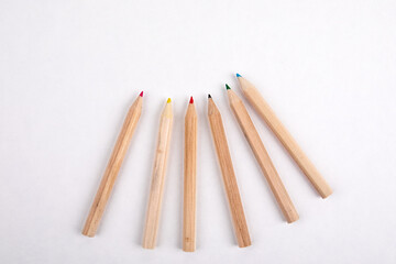 Wooden colored pencils on a white sheet of paper. Creativity, education and art