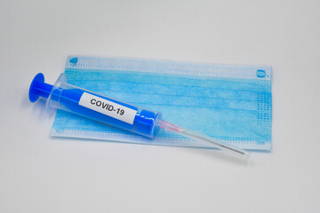 Mask and syringe on a white background