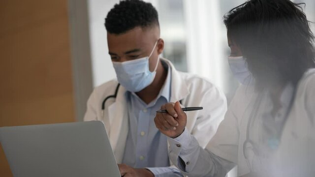 Young doctors working on laptop at the hospital