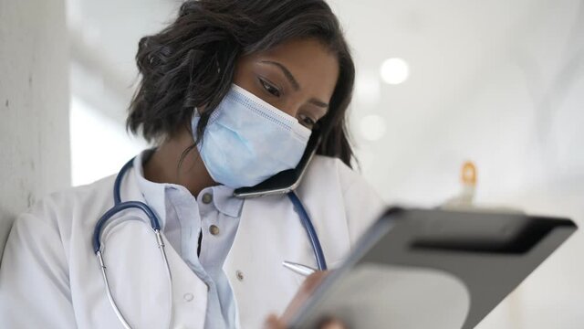 Woman doctor standing in hospital, wearing face mask