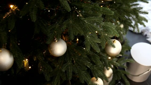 Festive Christmas tree with golden balls. Beautiful New Year's interior, branches of a Christmas tree close-up.