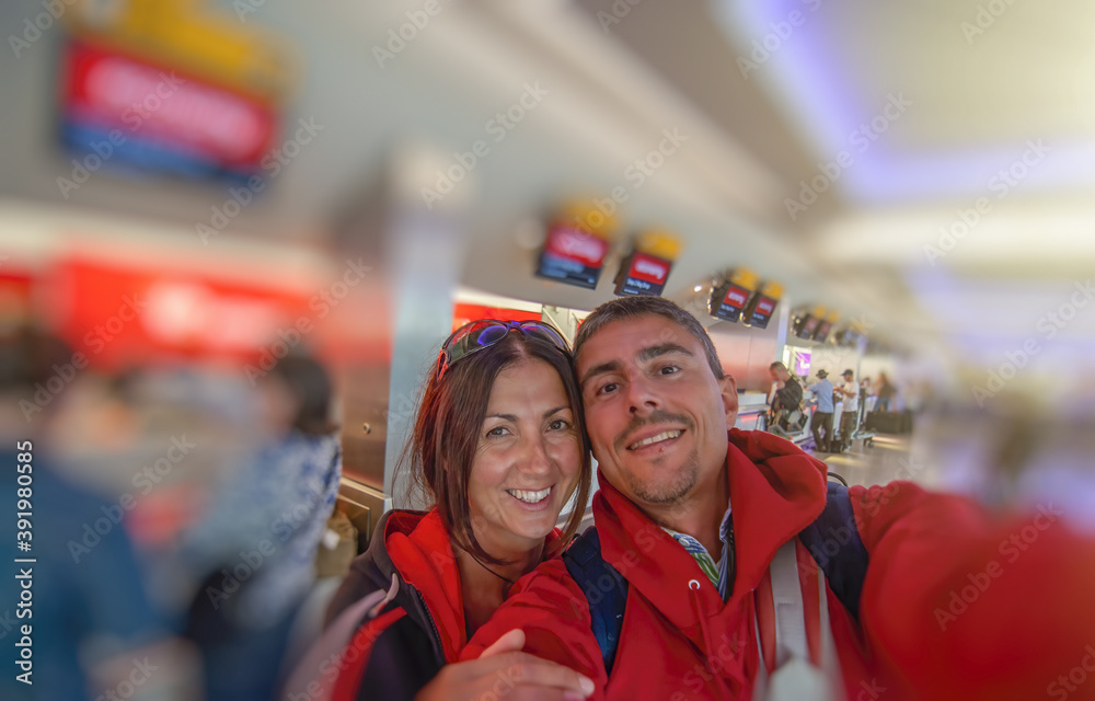 Sticker happy couple ready to fly after buying airplane ticket at the airport