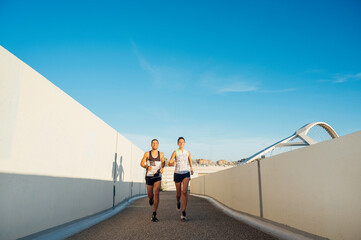 Obraz premium couple jogging between two walls in the city