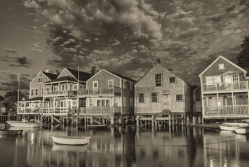 Naklejka premium Wooden homes over the ocean. Water reflections at sunset