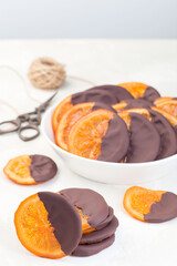 Homemade candied sliced oranges covered with chocolate, vertical
