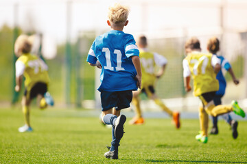 Boys playing in a soccer match. Football youth players kicking football ball in sunny day. Football...