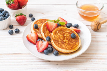 pancake with fresh blueberries, fresh strawberries and honey