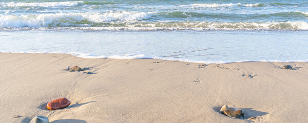 the waves of the sea on the sandy beach on a sunny day